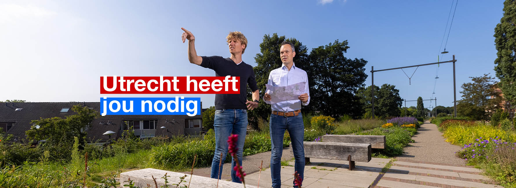 twee mannelijke landschapsontwerpers met een kaart in de hand op een oud treinspoor