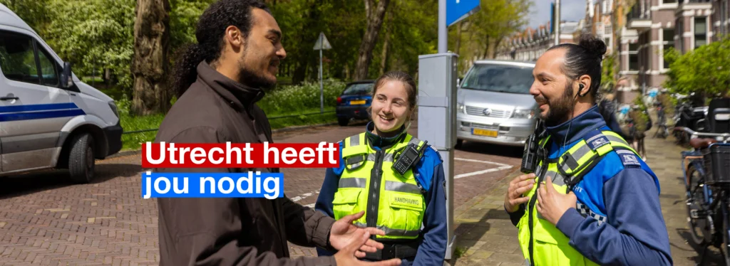 Man praat op straat met twee BOA's. Tekst in beeld: Utrecht heeft jou nodig